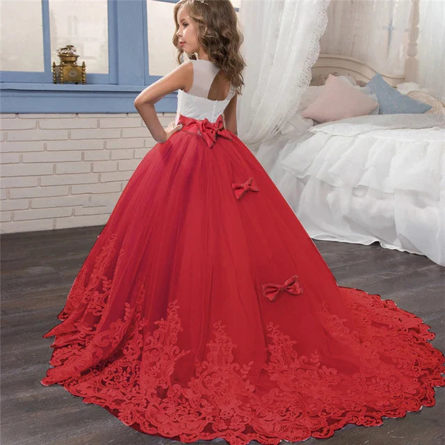 Long Kids party dress made of lace with embroidered flowers, bows, rhinestones, and sequins.