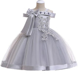 Party dress with bow and appliqué for ages 3 to 10.