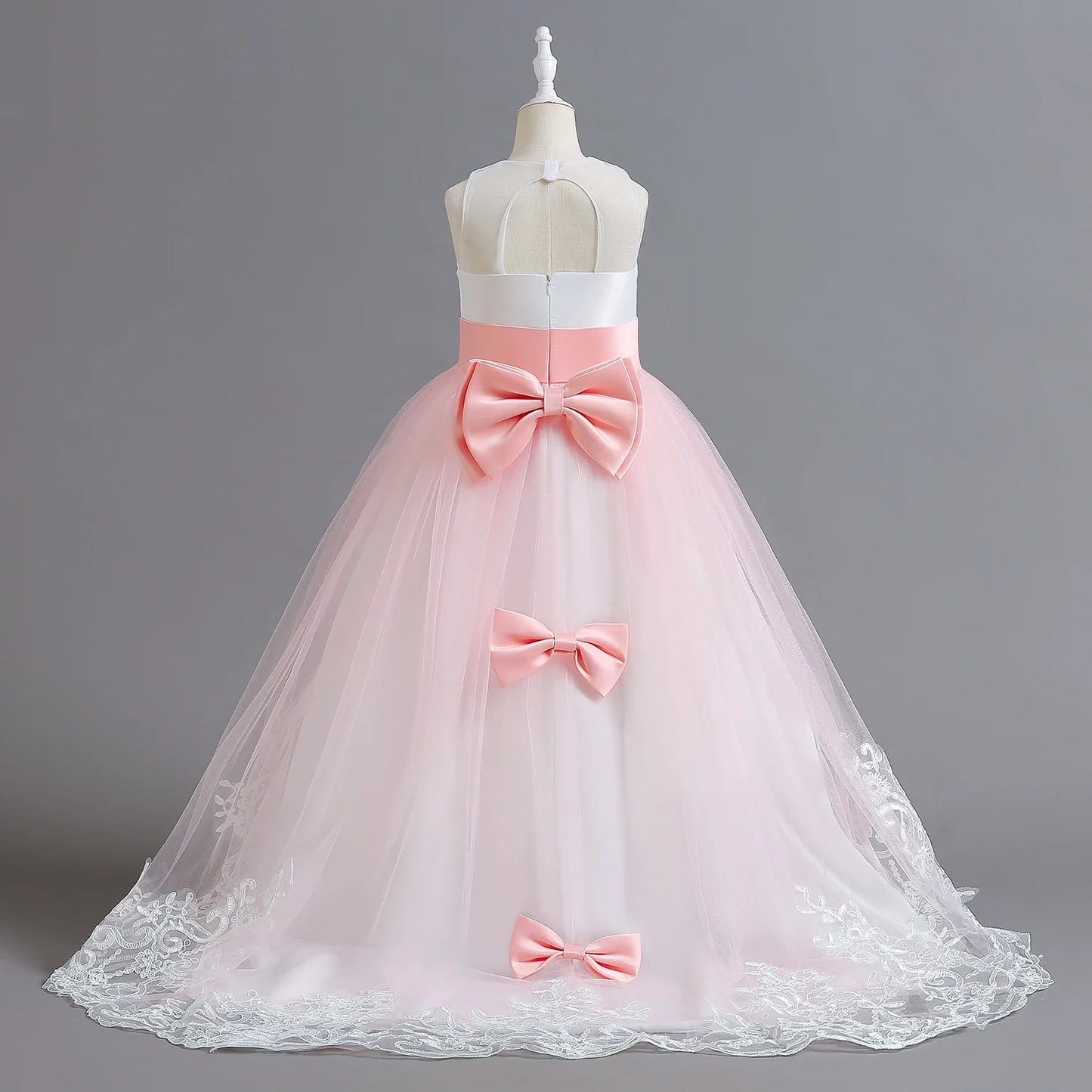 Long Kids party dress made of lace with embroidered flowers, bows, rhinestones, and sequins.