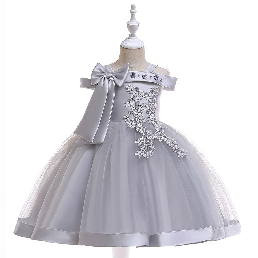 Party dress with bow and appliqué for ages 3 to 10.
