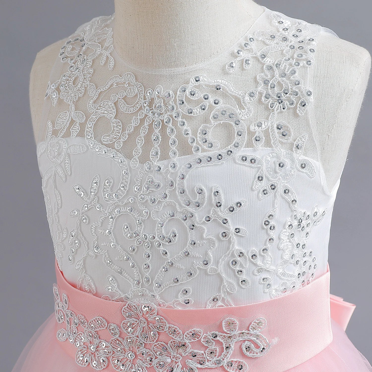 Long Kids party dress made of lace with embroidered flowers, bows, rhinestones, and sequins.