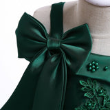 Party dress with bow and appliqué for ages 3 to 10.
