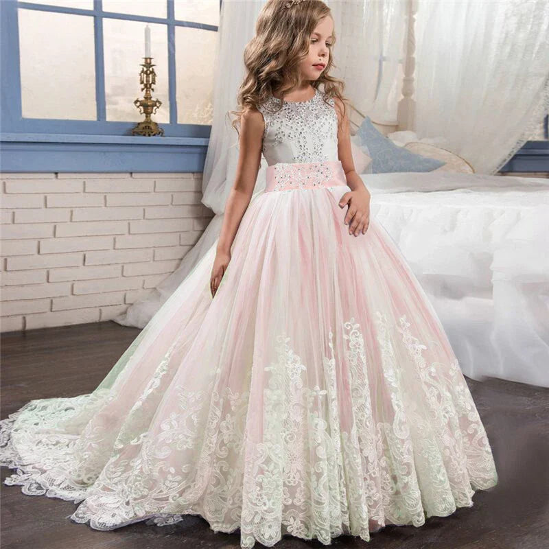 Long Kids party dress made of lace with embroidered flowers, bows, rhinestones, and sequins.